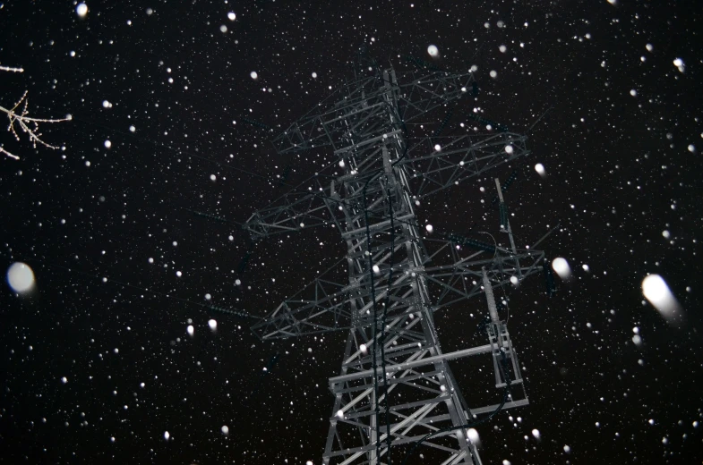 a dark snowy night at a telephone pole