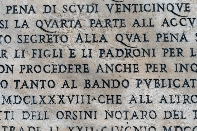 the inscription in latin script on a concrete wall