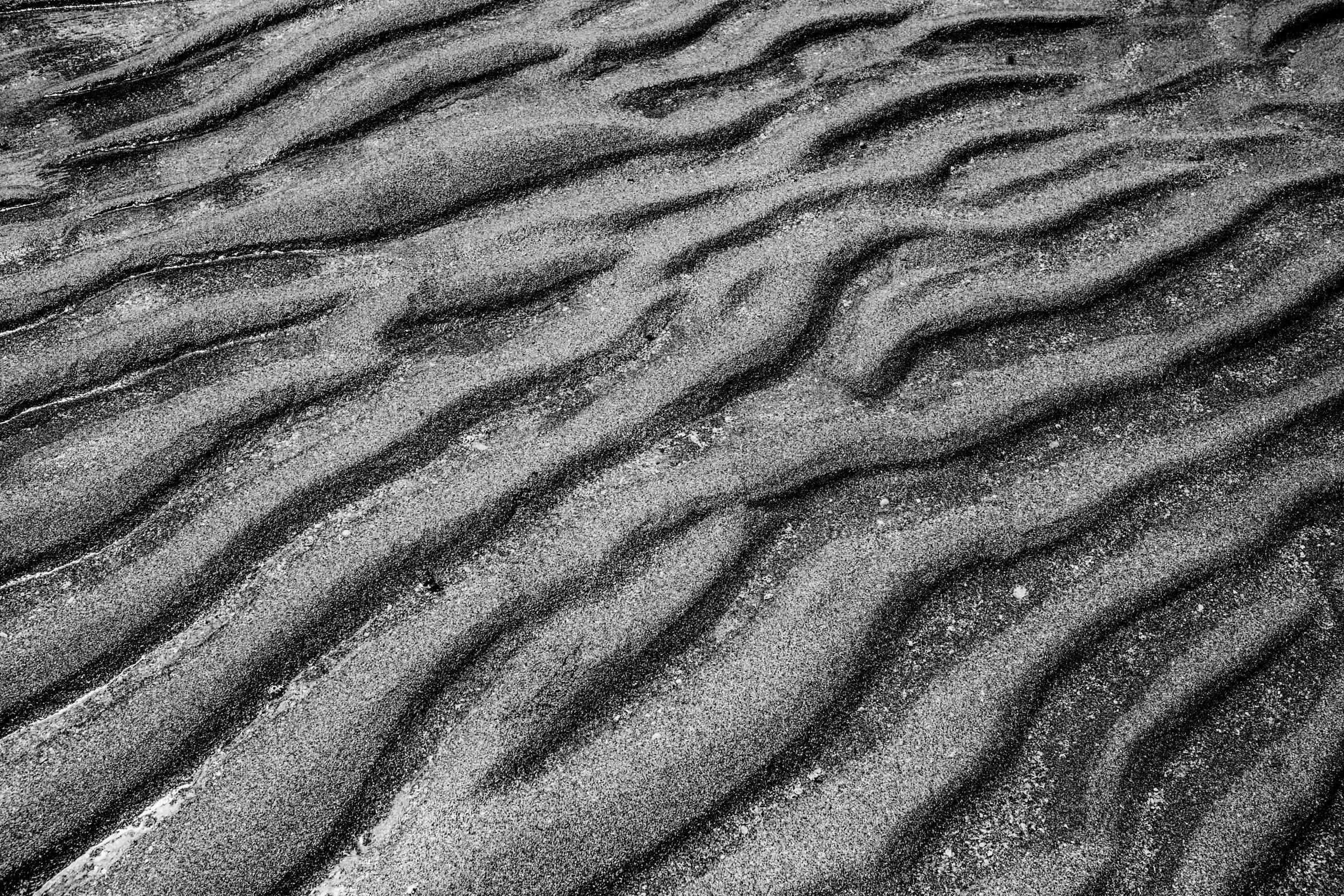 the bottom of a sand dune that is wavy