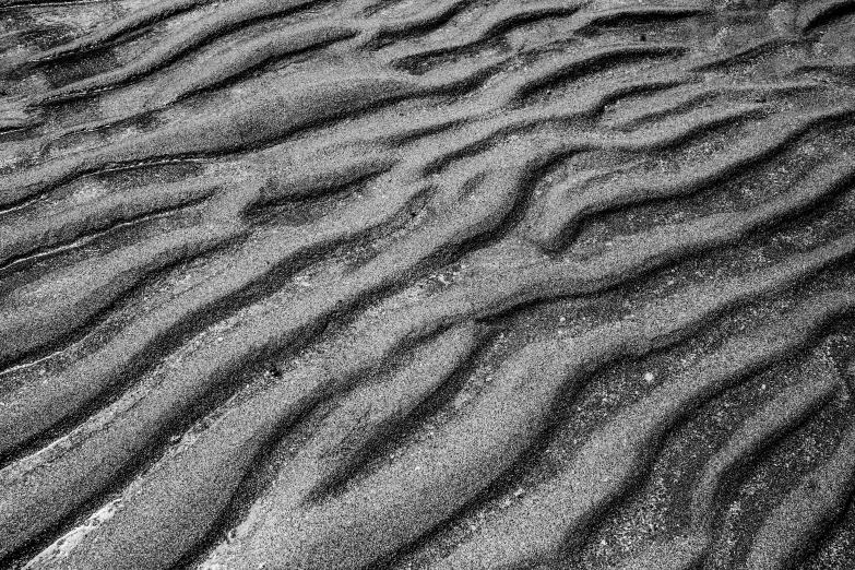 the bottom of a sand dune that is wavy