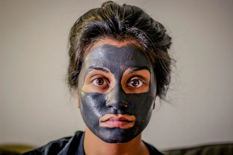 a woman with a black mask on looking straight ahead