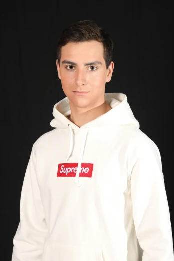a young man wearing a supreme sweatshirt with a supreme tag