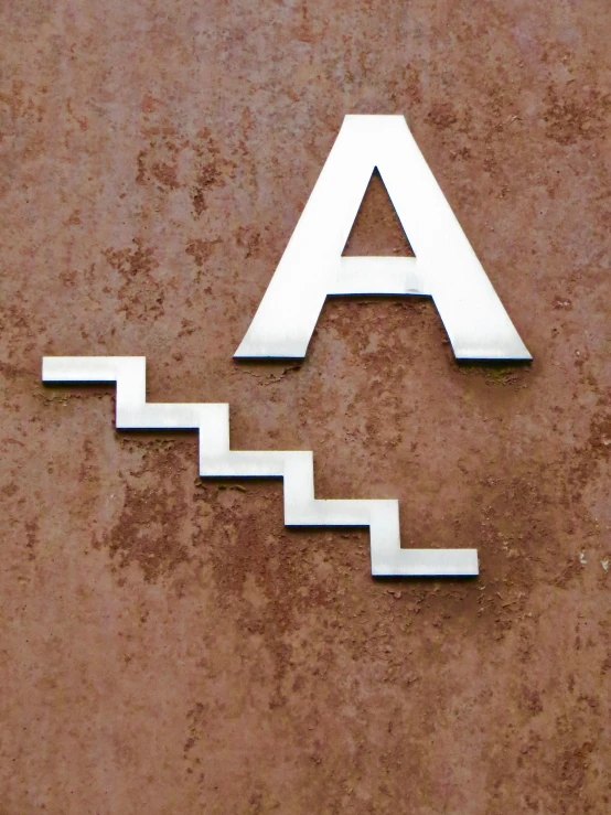 a sign attached to a wall depicting the letter a