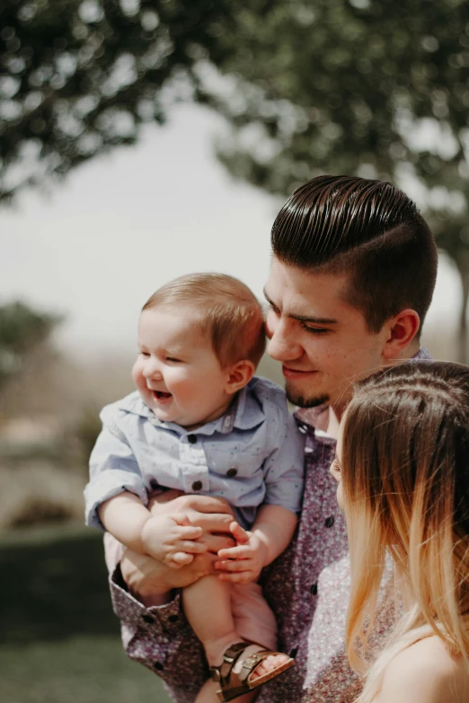 a man holding a baby with his hand held up