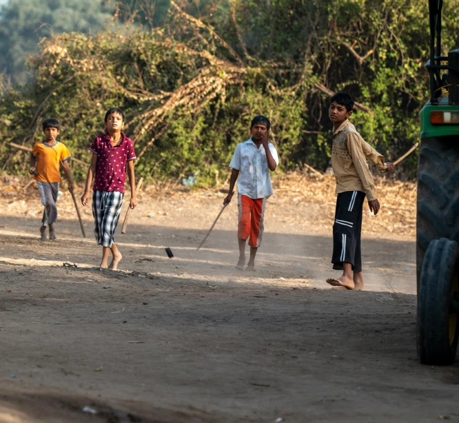 children and men walk together down the road