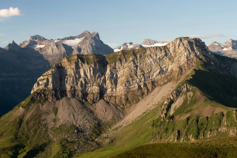 the mountain tops are covered in grass and bushes