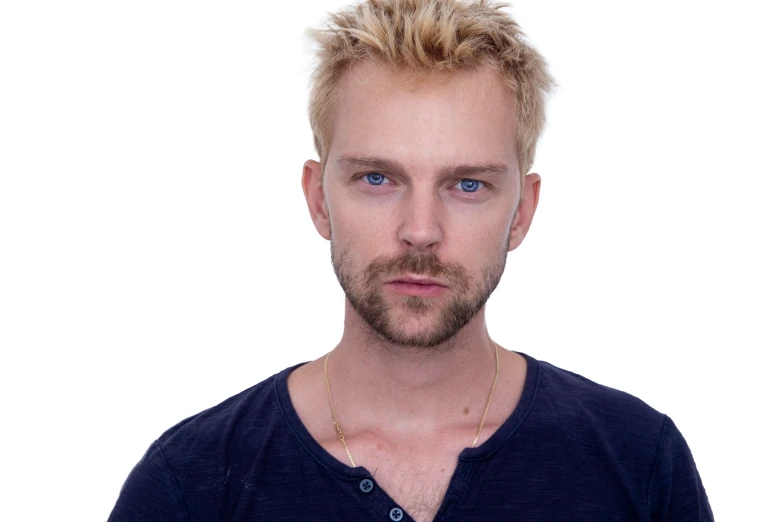 a man with blonde hair and blue eyes stares ahead