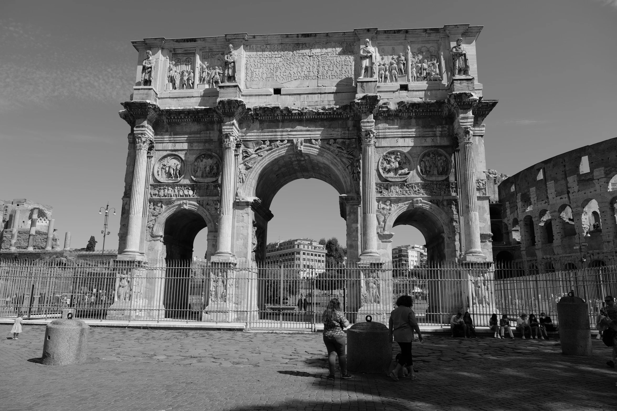 some people standing around looking at an old gate