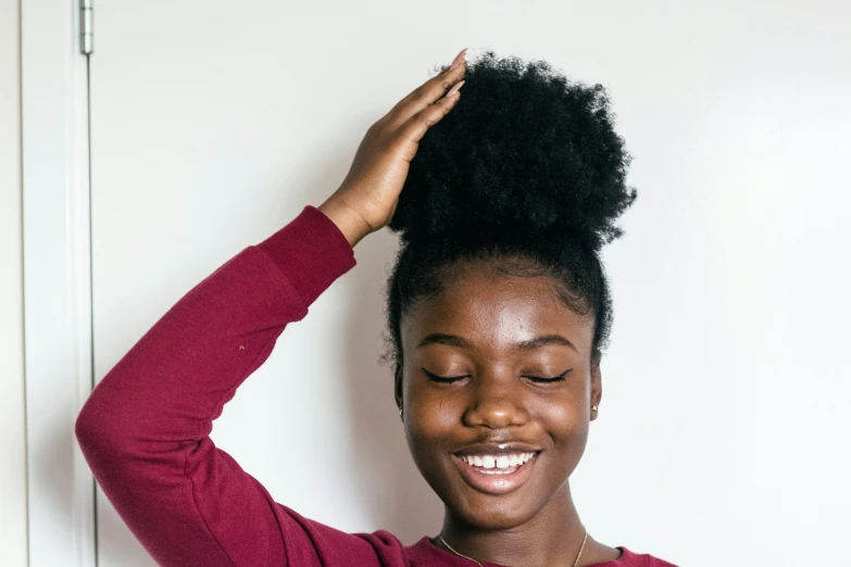 woman in red shirt with afro hairs looking back