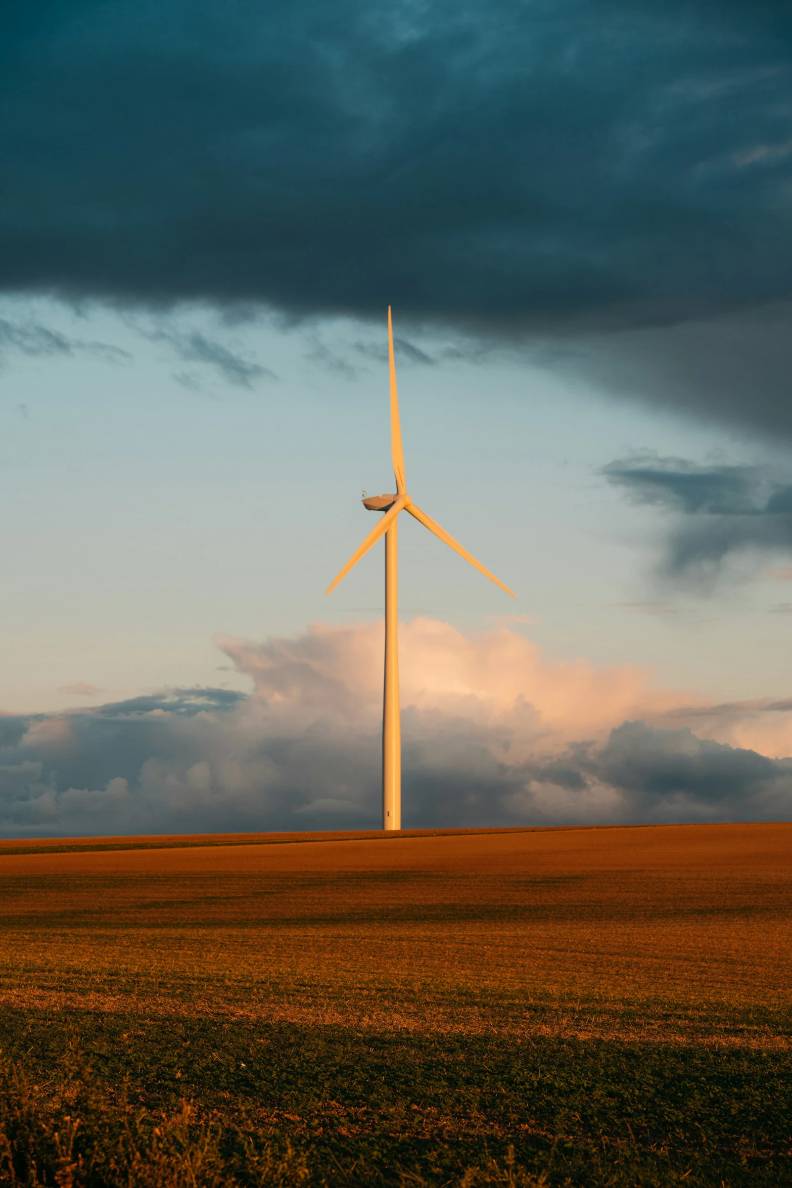 a large windmill in an open field at dusk