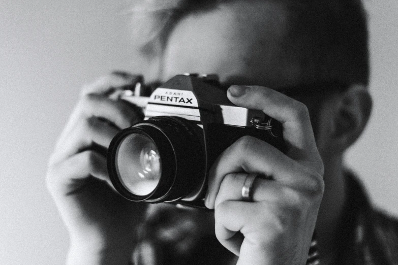 a man holding an old camera and taking a po