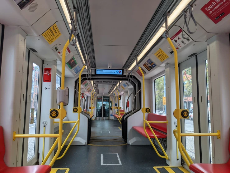 a very long train with yellow doors and some red seats