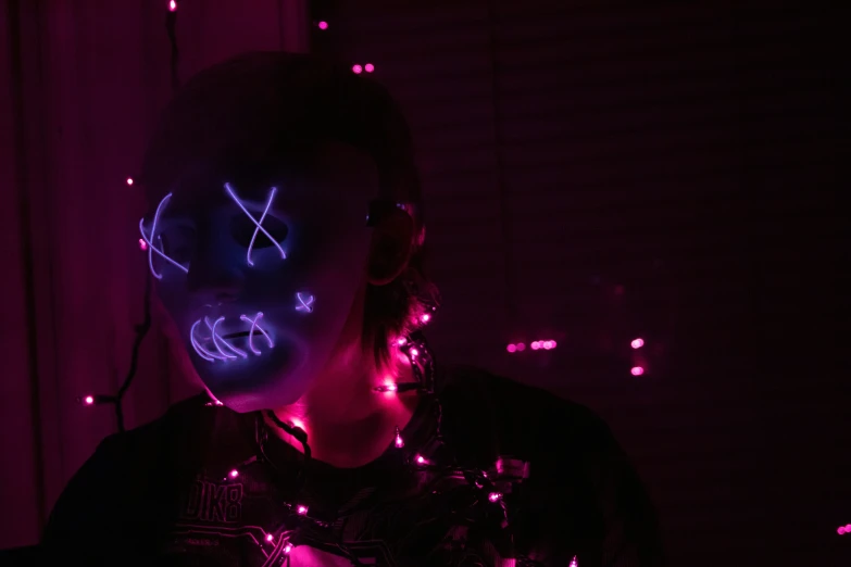 a girl with bright neon makeup standing in a dark room