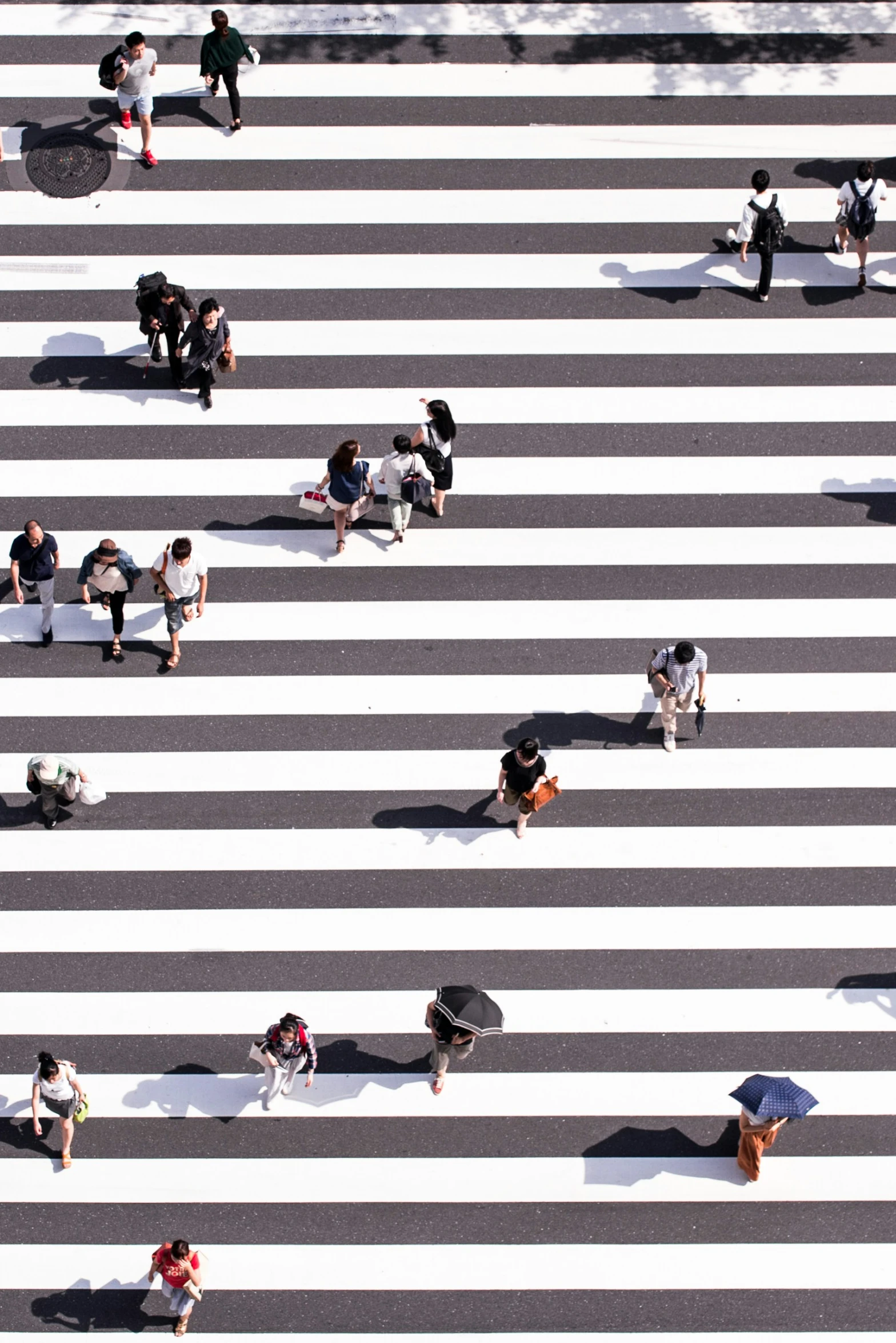 pedestrians crossing cross street in urban area while others walk by