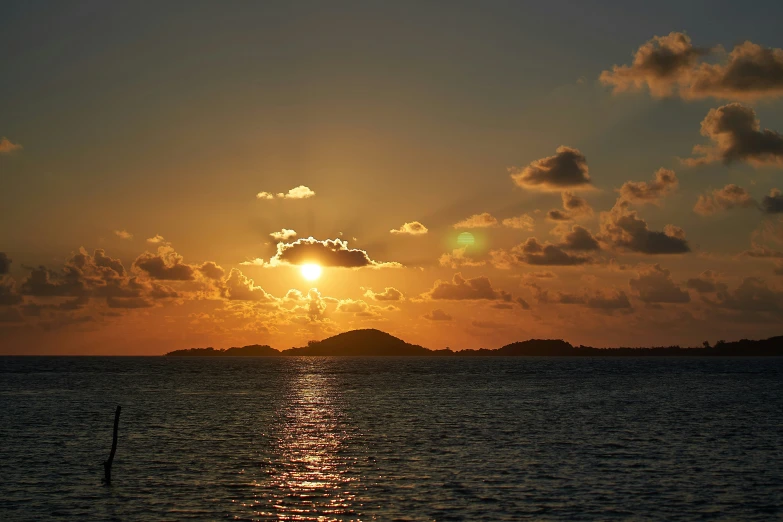 a sunset reflects off the calm water