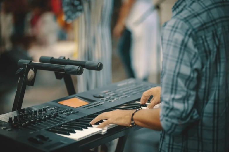 a man is playing the keyboard of a piano