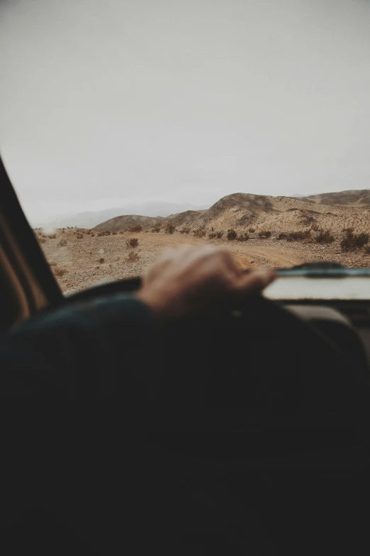 a car dashboard with desert and clouds in the background