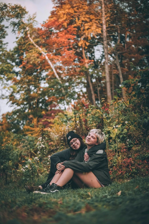 a couple is hugging and smiling together in the grass