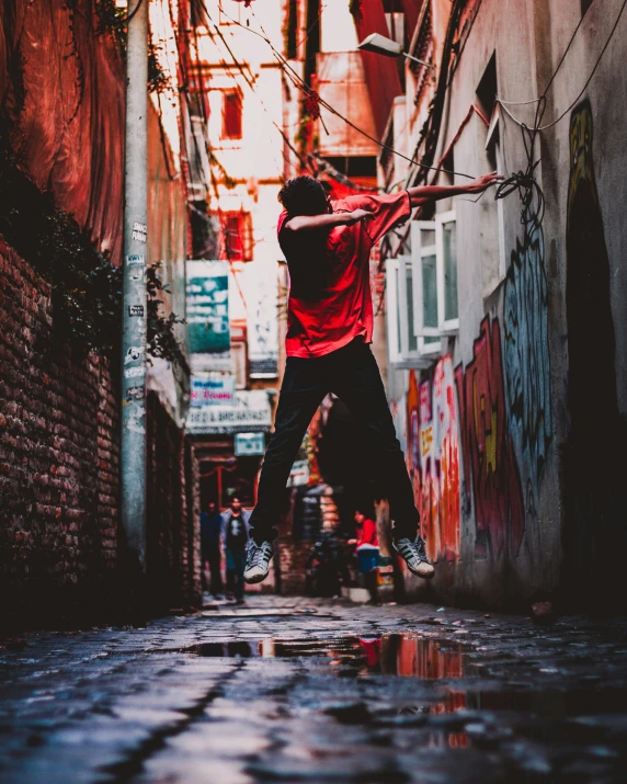 a man in red shirt jumping off a wall into the air