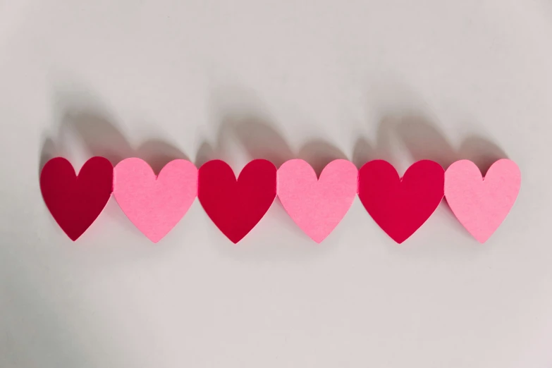 four pink and red hearts on white background