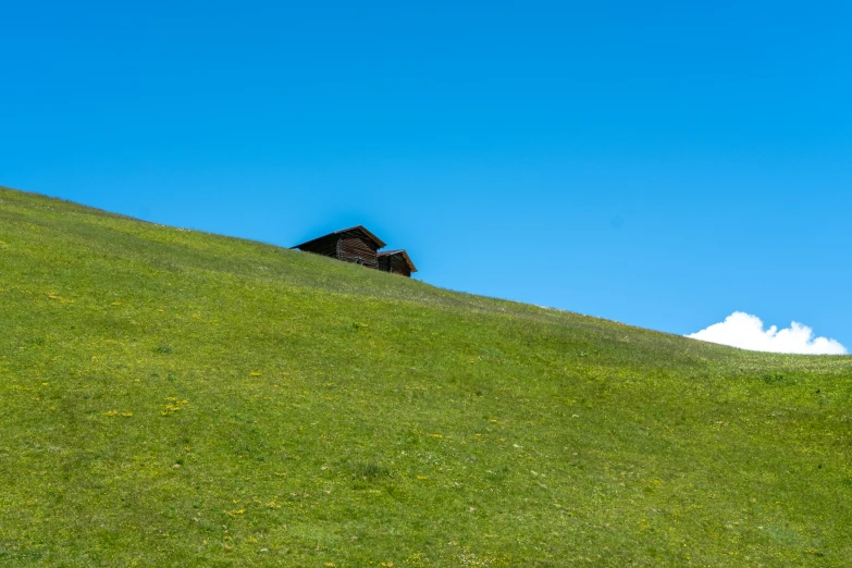 a hillside covered with green grass and a building