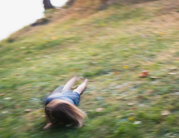 the blurry image shows a child laying on the grass