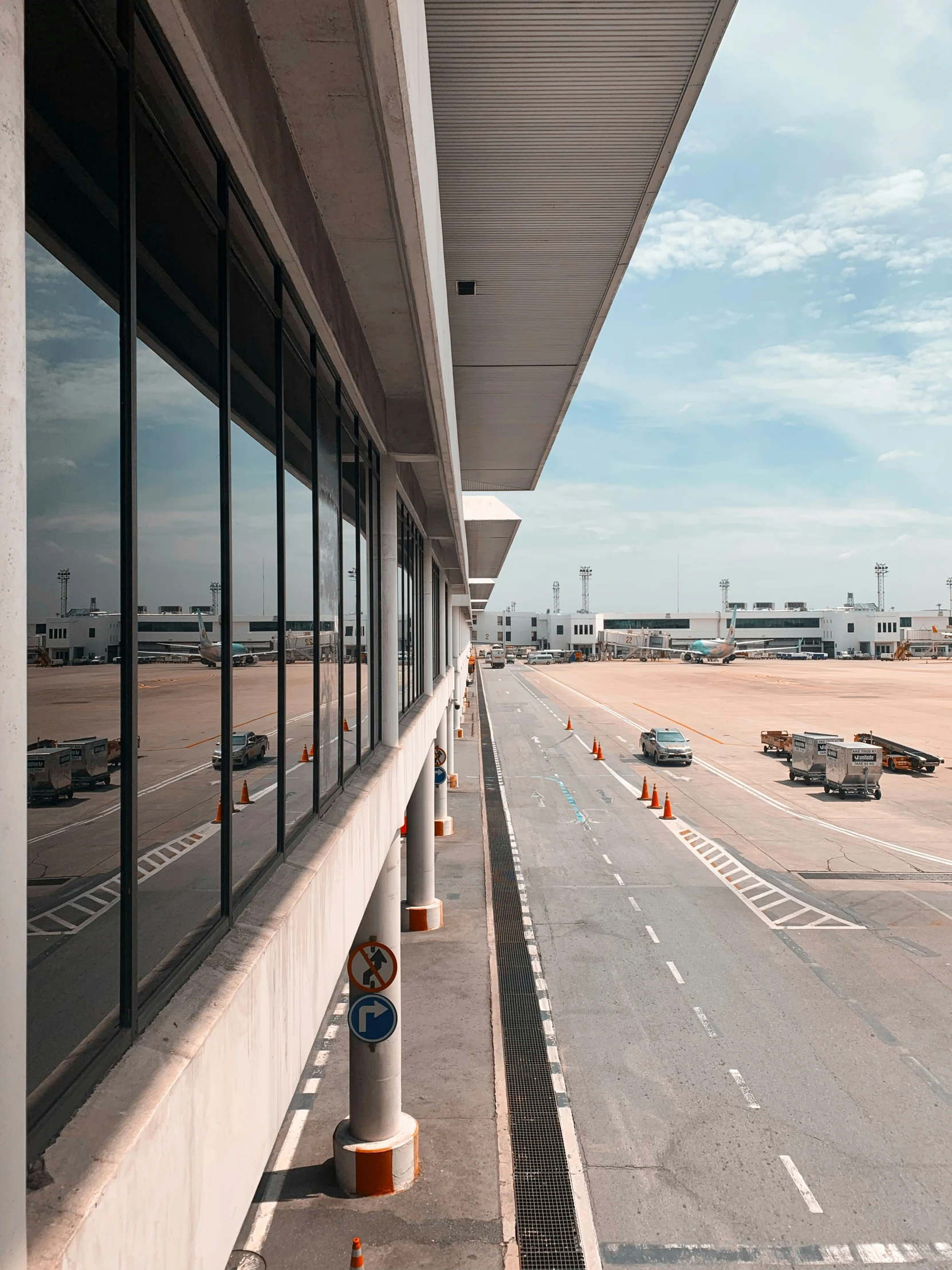 the windows of an airport terminal with multiple parking meters outside