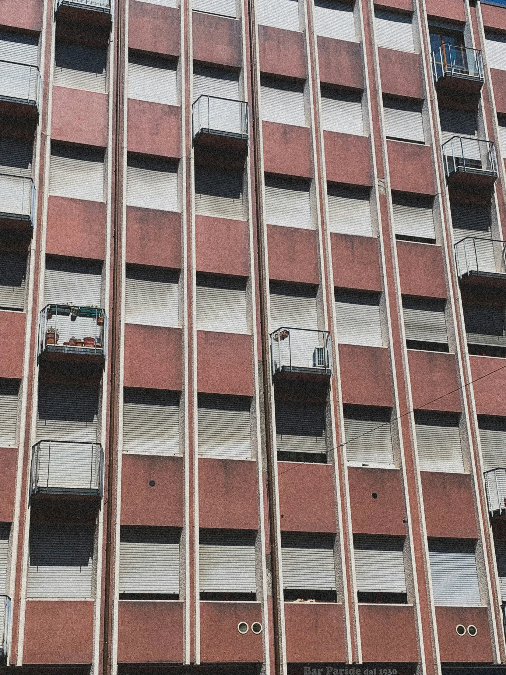 a tall brick building with windows and bars