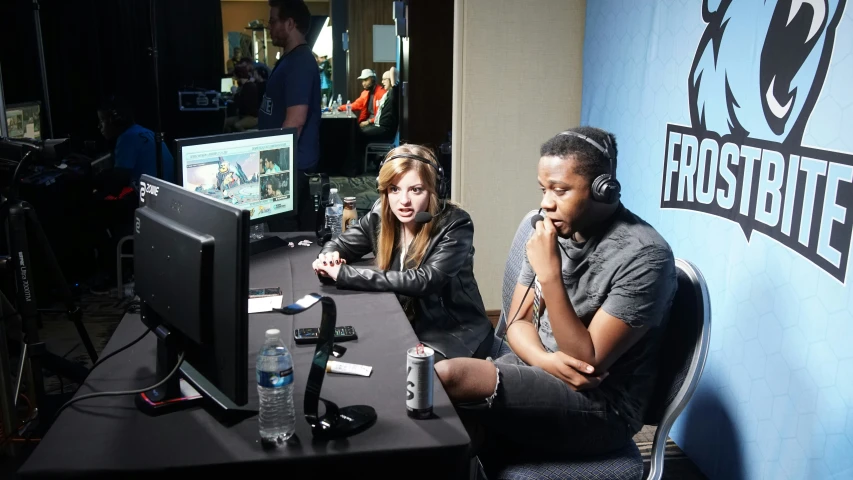 two people sit at a table playing video games