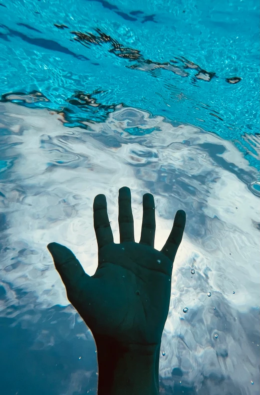 a man standing under water holding his hands up