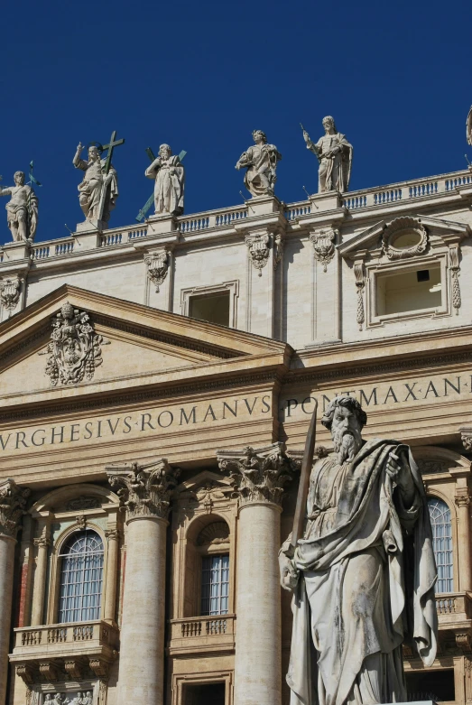 a closeup image of a statue of saint paul in front of the dome of an historic building