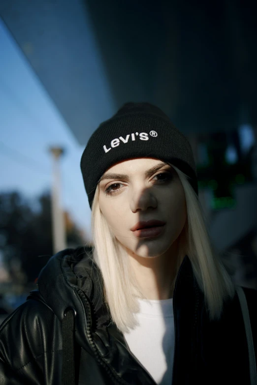 a female in a black jacket and a hat