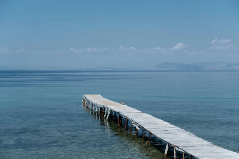 a long wooden dock is sitting in the water