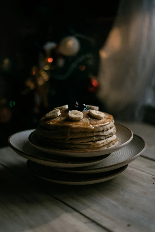 a stack of pancakes on a plate with a candle