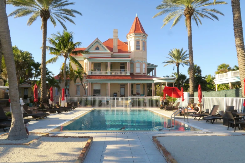 a pool is next to a house that has many chairs