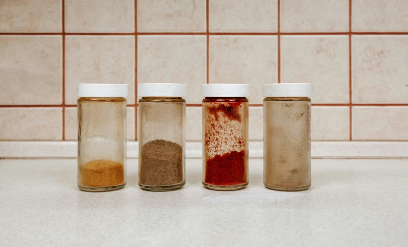 three jars filled with different types of spices