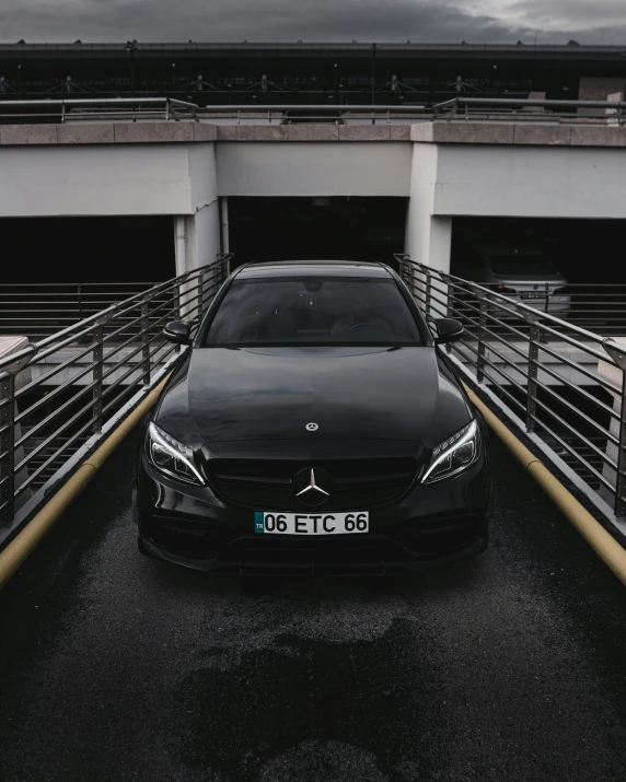 a mercedes benz is parked in front of two open garages