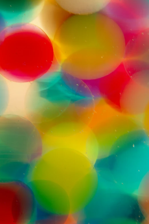 several colored balls floating in water on a bright day