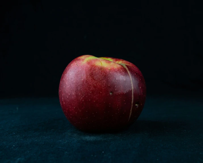 an apple on the ground is shown against a black background