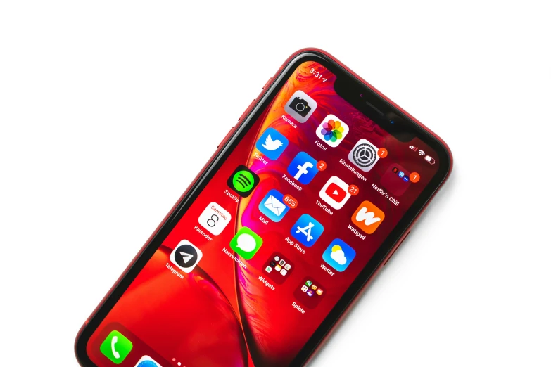 a red smartphone with different app icons displayed on the screen