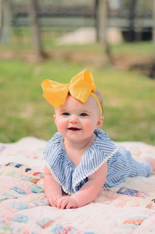 a baby on the grass is smiling at the camera