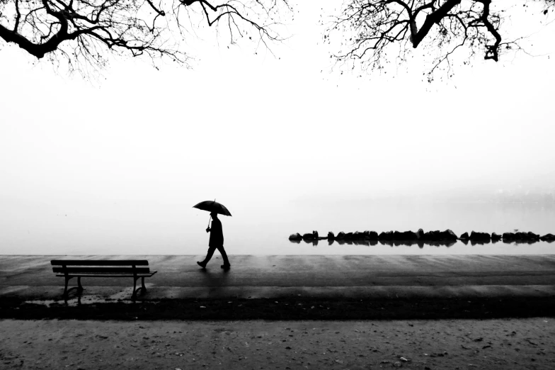 there is a person walking down the street with an umbrella