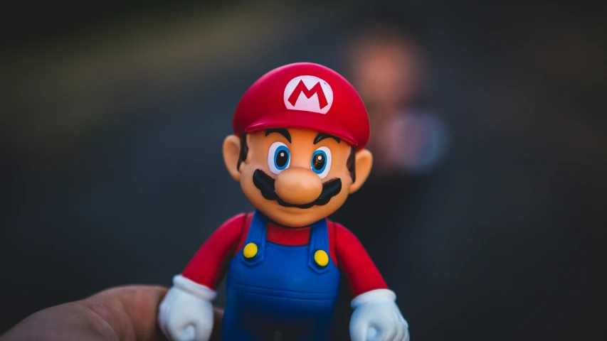 this is a man holding a toy mario that is standing up