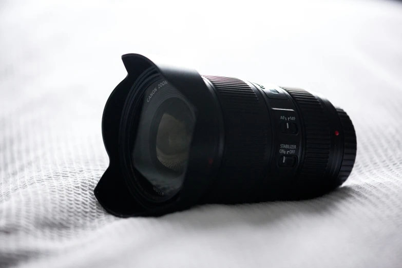 a camera lens sitting on top of a bed