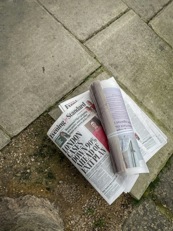 the newspaper is lying on the ground next to a roll