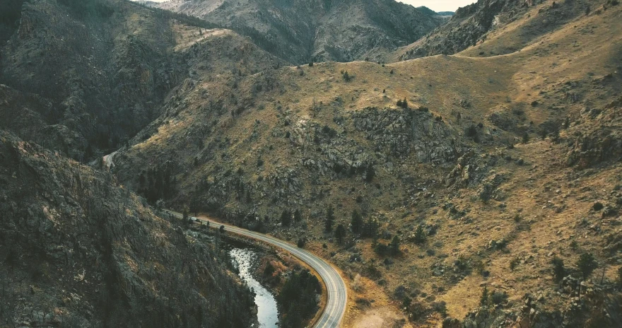 an aerial s of a road winding through the mountains