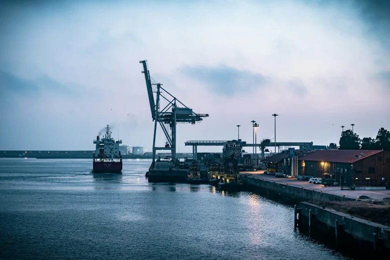 two large ships sit at the dock near some buildings