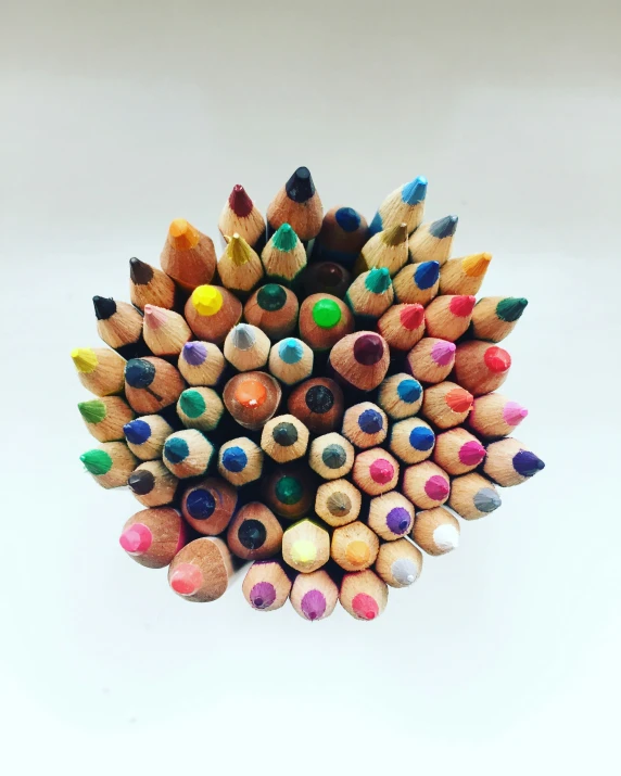 a bunch of colored pencils that are sitting together