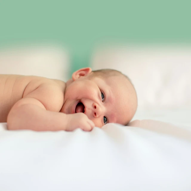 a baby is laying on top of the sheets