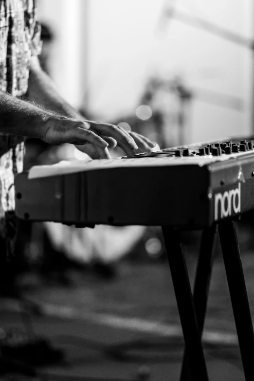 a man is playing a keyboard with one hand